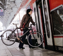 Frau mit Rad vor einem Zug (c) DB AG