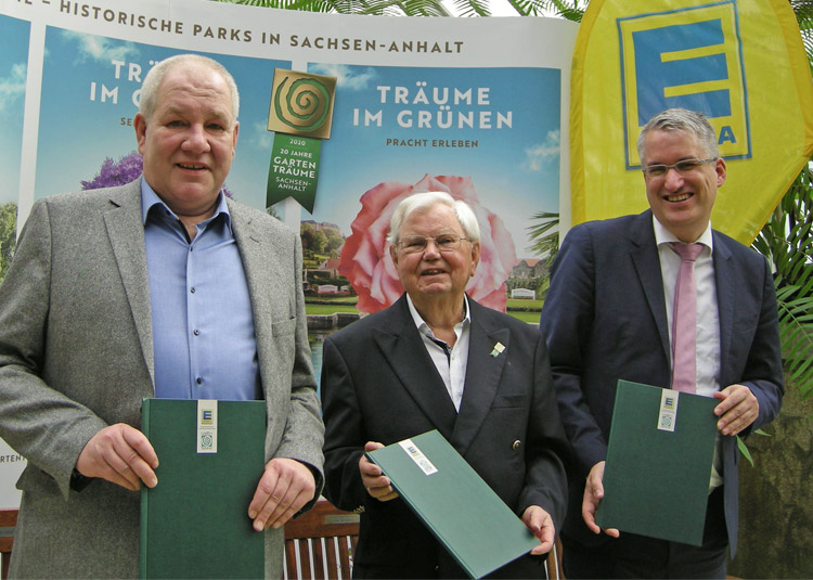 Foto zeigt Thomas Beyer (EDEKA), Claus Mangels (Gartenträume e.V.) und Thomas Einsfelder (IMG Sachsen-Anhalt) – stehend; in den Händen halten sie die Kooperationsvereinbarung