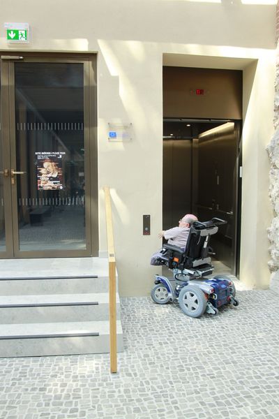 Rollstuhlfahrer am Ausstellungseingang zum Augusteum des Museums Lutherhaus in der Lutherstadt Wittenberg
